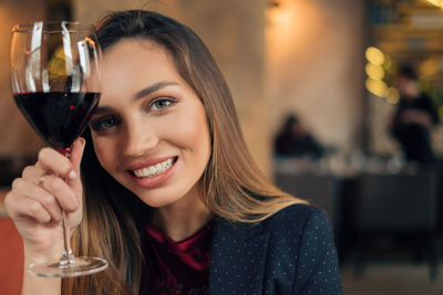 Close-up portrait of young woman drinking glasses outdoors