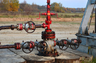 Industrial piping with steel flanges and bolts on oil field. fuel pipes valves and crude pipelines. 