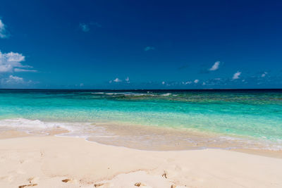 Scenic view of beach against blue sky