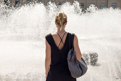 Rear view of woman standing in water