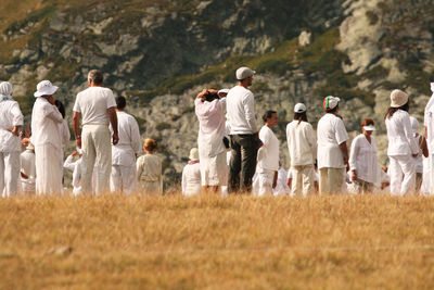 Rear view of people walking on field