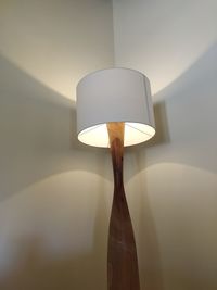 Low angle view of illuminated lamp on wall at home