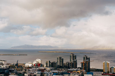 High angle view of buildings by sea against sky