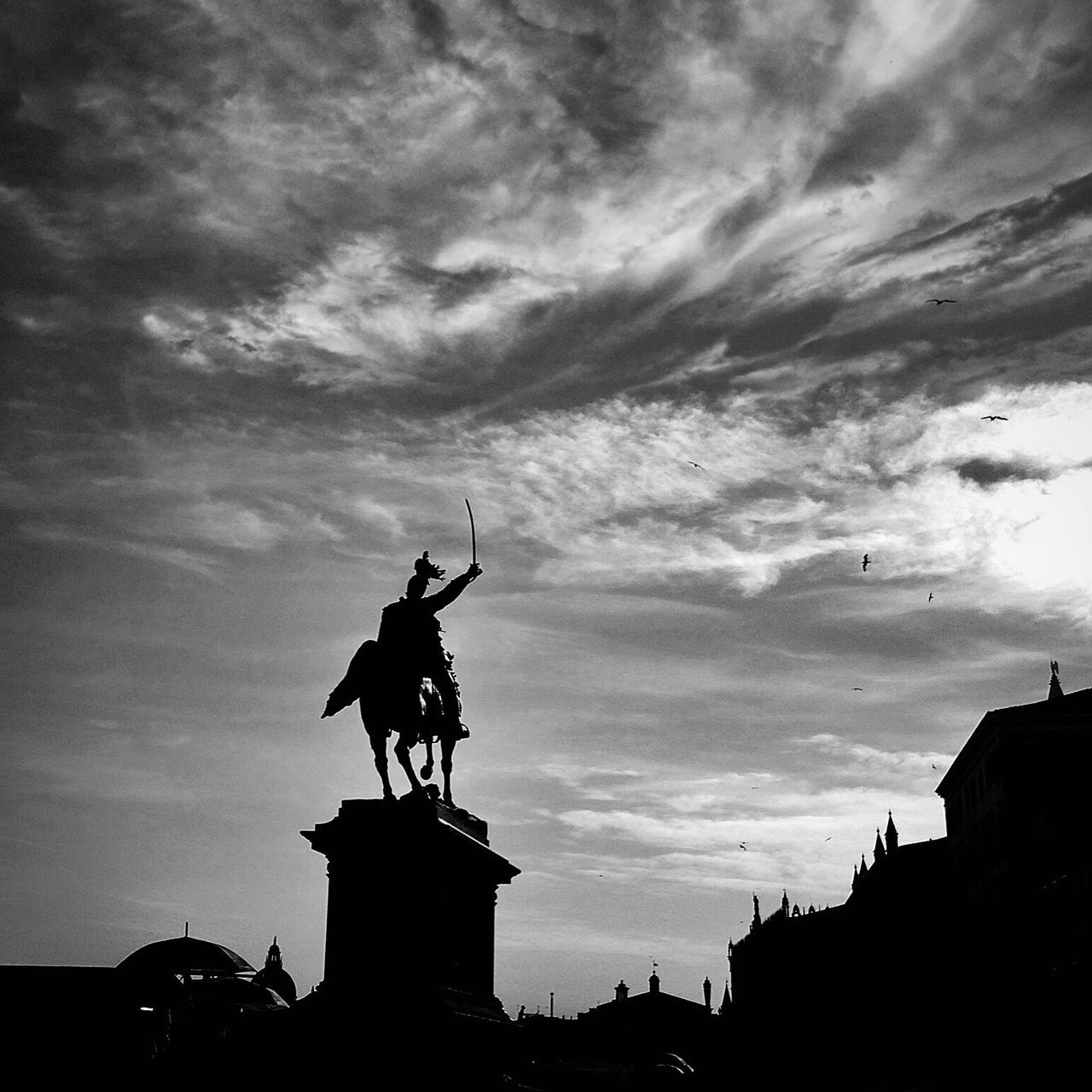 sky, low angle view, statue, architecture, built structure, sculpture, building exterior, human representation, silhouette, cloud - sky, art and craft, art, cloudy, creativity, cloud, animal representation, city, dusk, outdoors