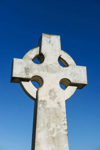 Low angle view of cross against clear blue sky