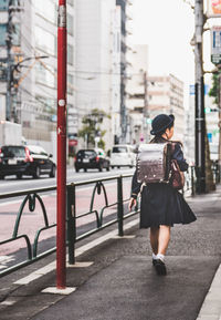 Full length of woman walking on street in city
