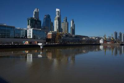 Reflection of buildings in city against sky