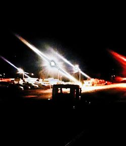 Cars on road against sky at night