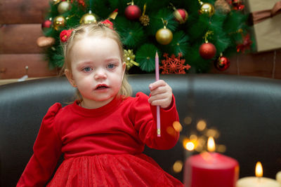 Portrait of cute girl playing with christmas tree