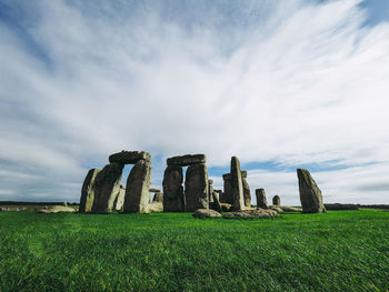 Built structure on field against cloudy sky