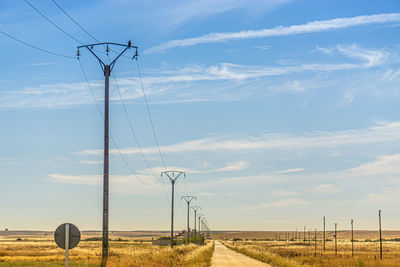 Electricity pylon on field against sky