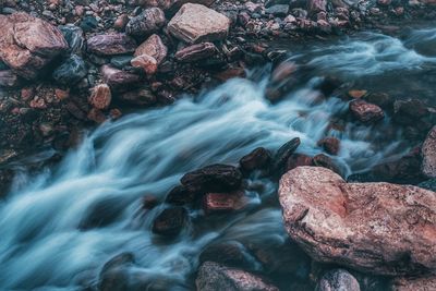 High angle view of stream flowing through rocks