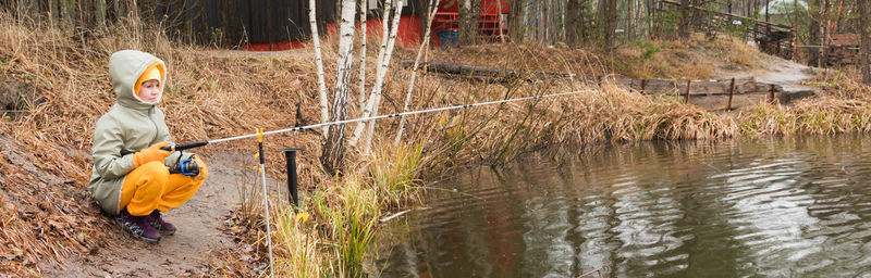 Boy in river by plants