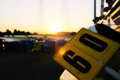 Close-up of information sign on road at sunset