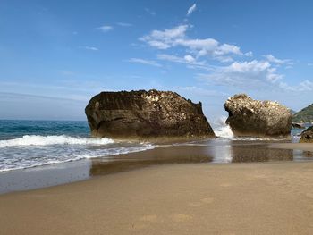 Rocks on beach against sky