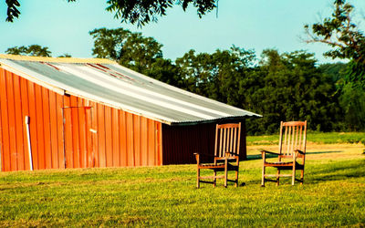 Empty chairs on grass field