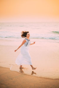 Rear view of woman standing at beach