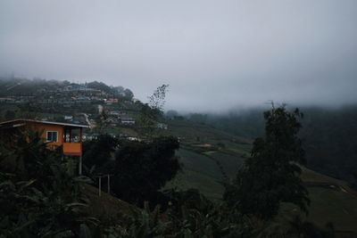 Scenic view of trees and buildings against sky