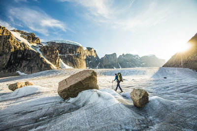 Mountaineer navigates glacier below mountains in akshayak pass.