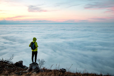 Rear view of man standing in sea against sky