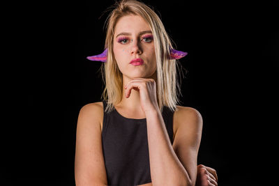 Portrait of beautiful woman against black background