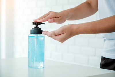 Midsection of person holding glass bottle