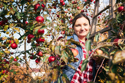 Portrait of young woman standing on tree