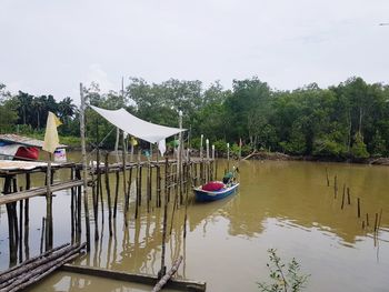 Boats moored on lake against sky