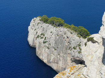 High angle view of rocks by sea against sky