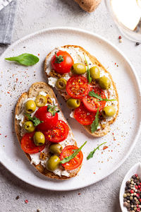 Bruschettas with olives and fresh tomatoes and wineglass