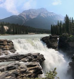 Scenic view of waterfall against sky