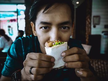 Portrait of man eating ice cream in restaurant