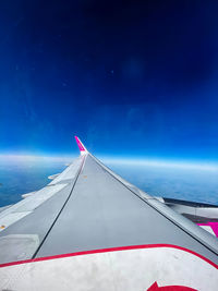 Airplane flying over sea against blue sky