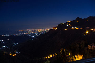 Illuminated city against sky at night