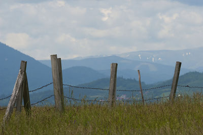 Wooden fence on field against sky