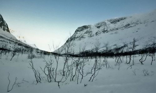 Scenic view of lake by snowcapped mountain against sky