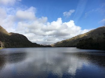 Scenic view of lake by mountains against sky