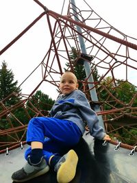 Low angle view of boy on grassy field against sky