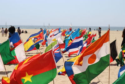 Flags at beach against clear sky