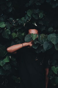 Close-up of young man standing amidst plants