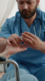 Male nurse checking pulse of patient in clinic