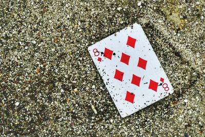 High angle view of playing card on sand at beach