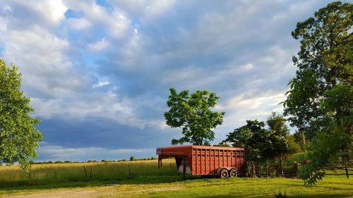 Barn on field against sky