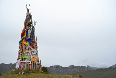 Low angle view of cross on mountain against sky