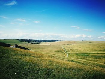 Scenic view of grassy field against cloudy sky