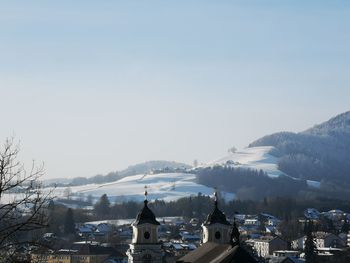 Buildings in city against sky during winter