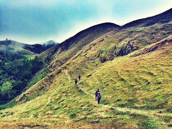 People on mountain against sky