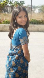 Portrait of smiling young woman standing outdoors