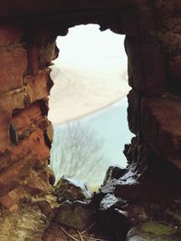 Rock formation on sea shore against sky