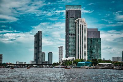 View of modern buildings against cloudy sky